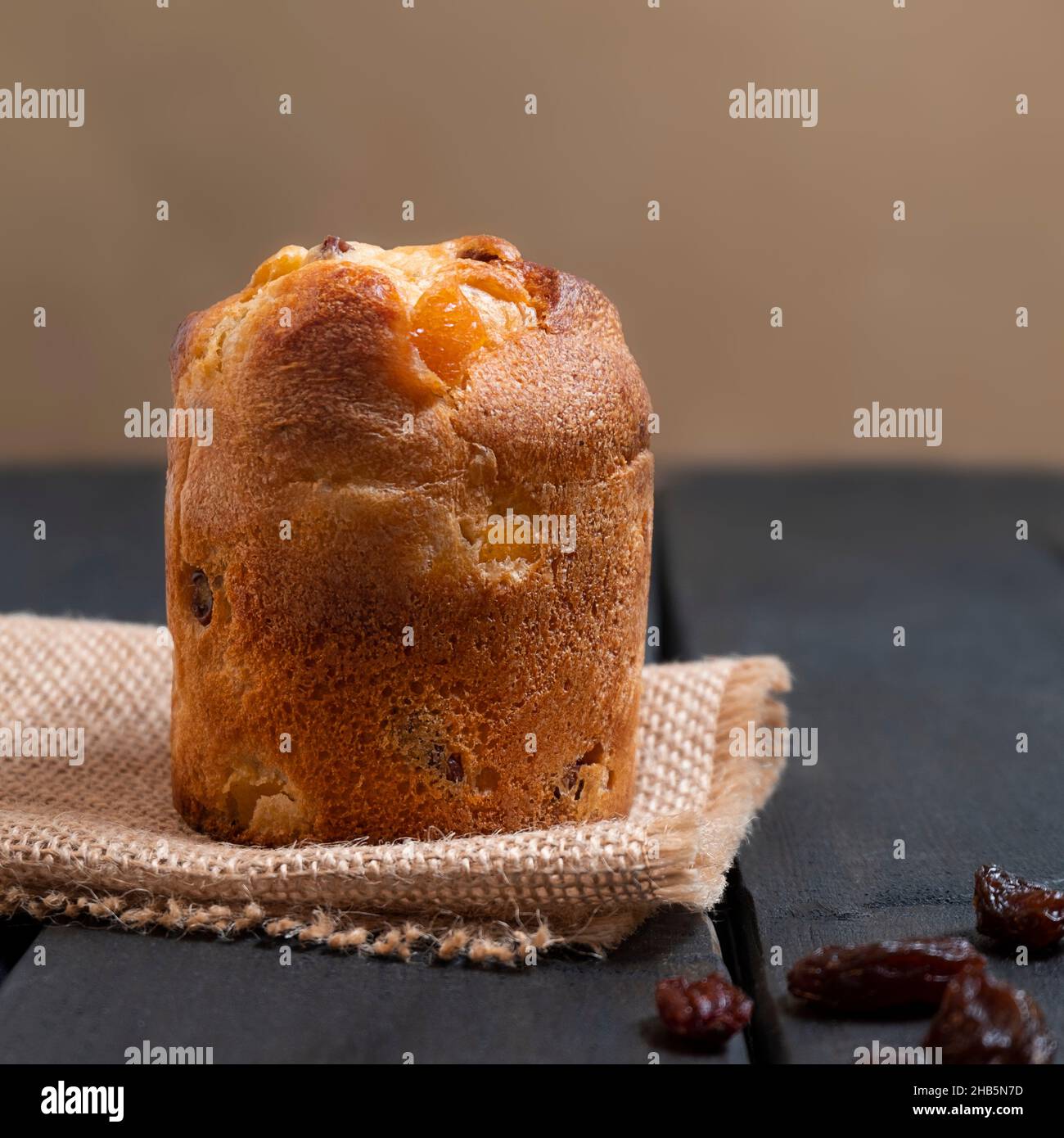 Dessert italiano mini panettone con uvetta su sfondo di legno scuro, orientamento verticale Foto Stock