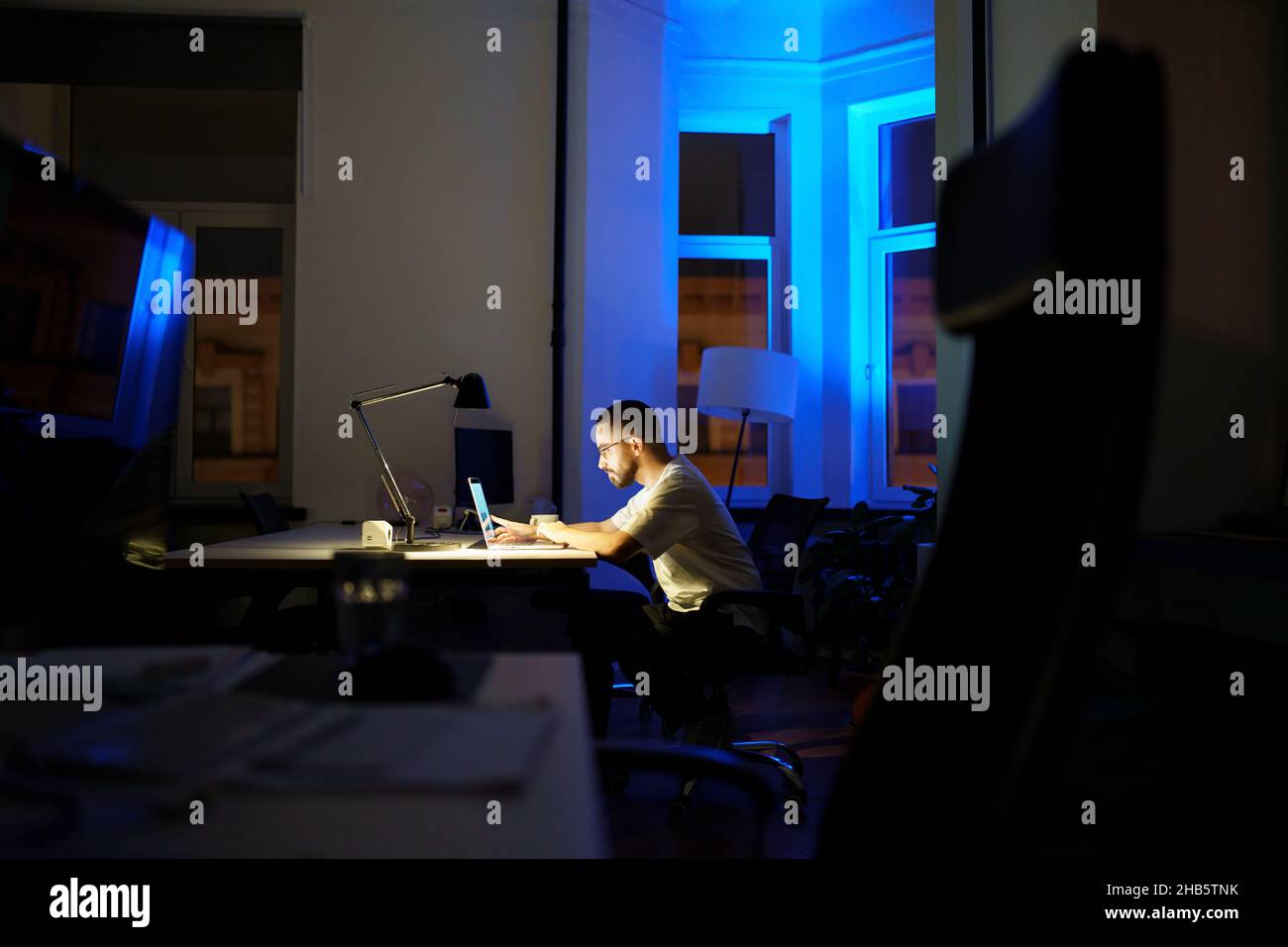 L'uomo workaholic rimane in ufficio straordinario si prepara per la presentazione di affari o il lancio di startup di notte Foto Stock