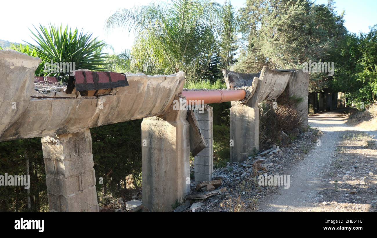Acqua che scorre attraverso il canale di irrigazione in necessità di riparazione nella campagna andalusa, in Spagna Foto Stock