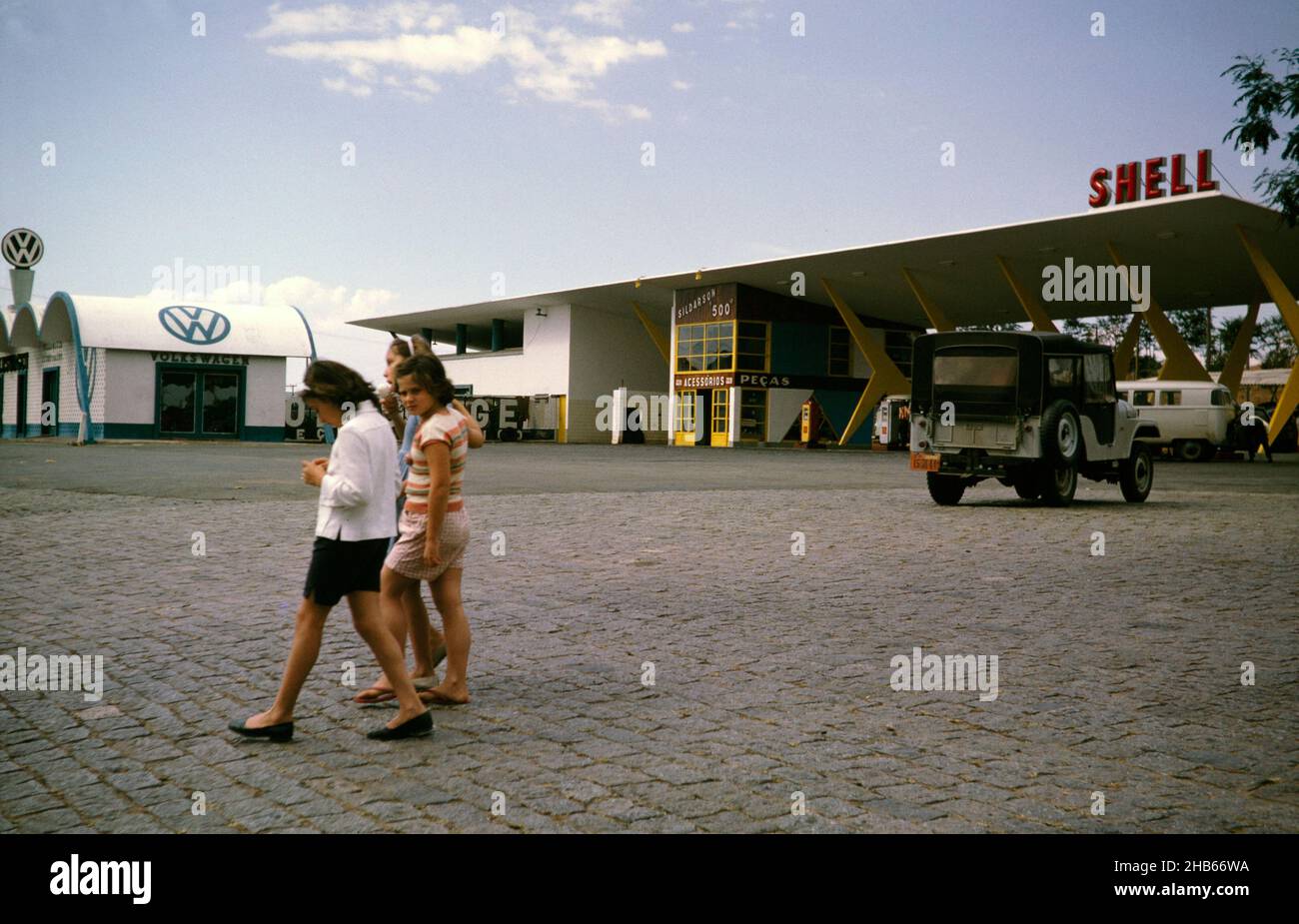 Stazione di benzina Shell vicino a San Paolo, Brasile, 1962 concessionaria auto Volkswagen in background Foto Stock