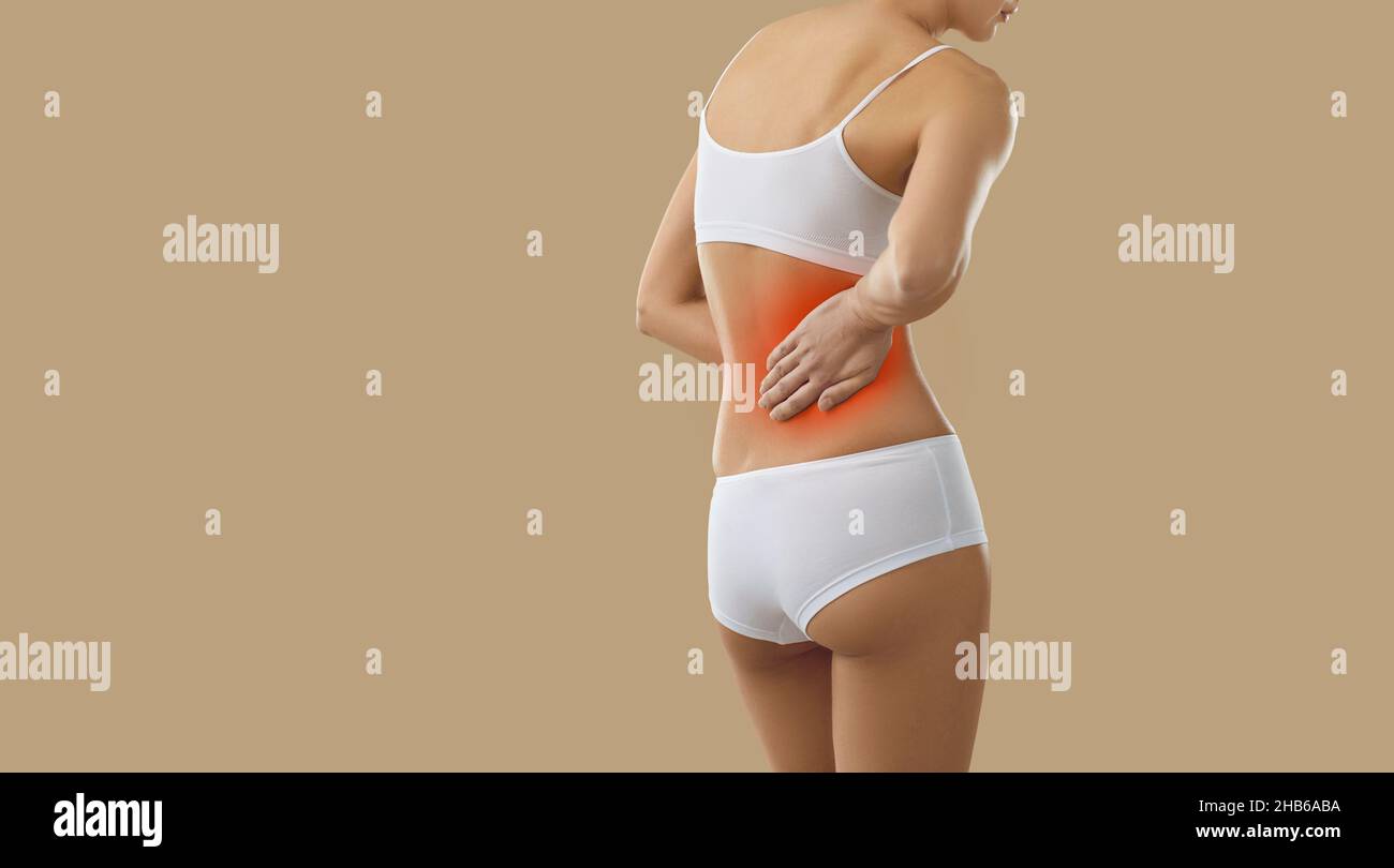 Donna che soffre di mal di schiena più basso a causa di malattie renali su sfondo spazio copia Foto Stock