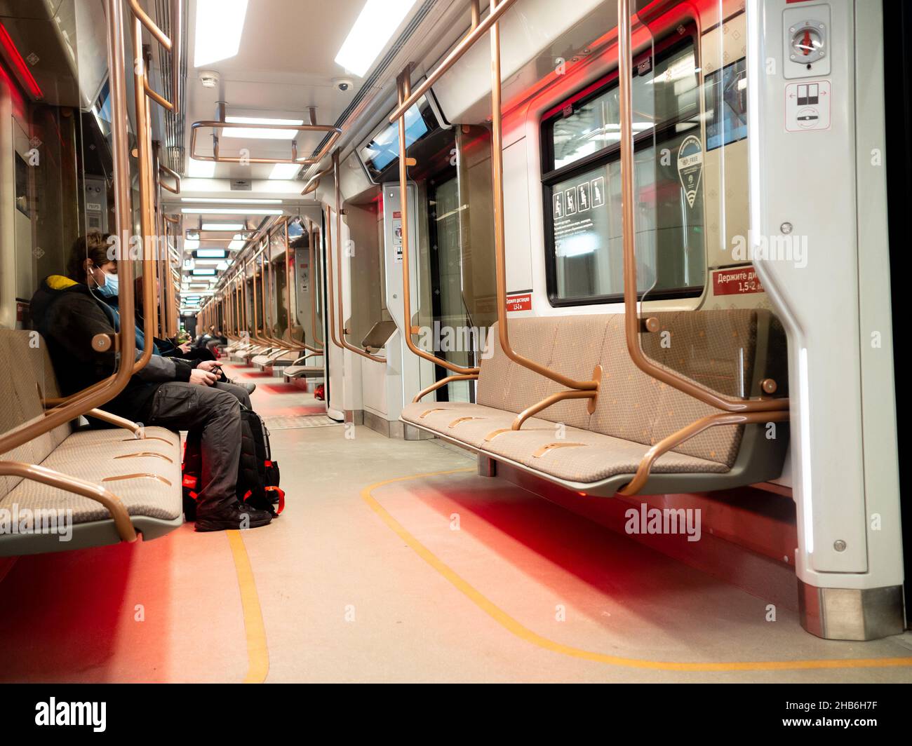 Mosca. Russia. Dicembre 8, 2021. L'interno di una moderna carrozza mezzo-vuota della metropolitana di Mosca. Passeggeri che indossano maschere protettive contro il ceppo omicron di infezione da coronavirus. Foto Stock