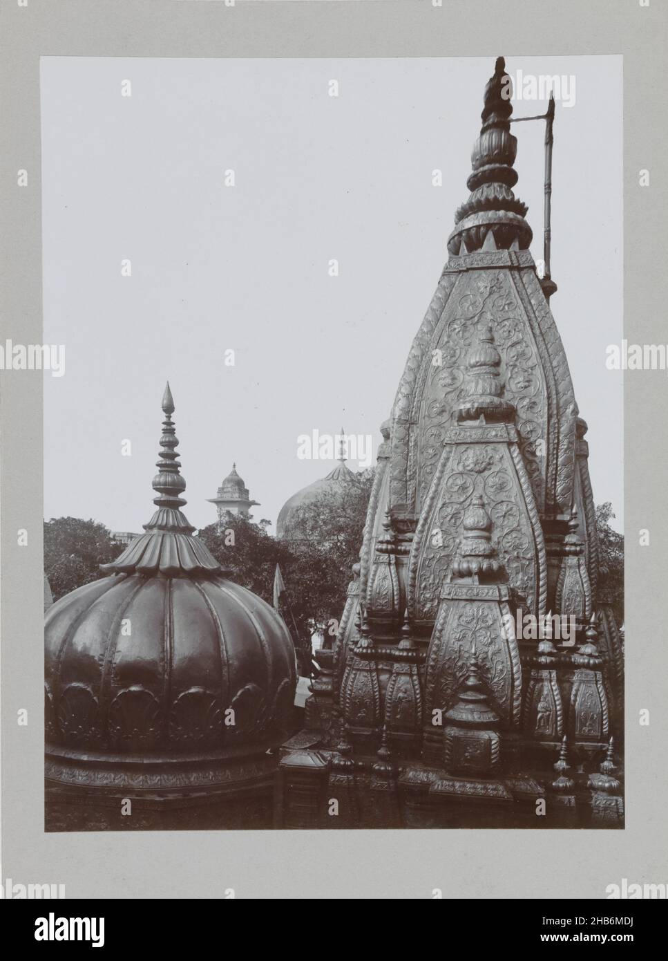 Tempio di Shiva a Benares, questo tempio è il famoso tempio di Shiva di Kashi Vishvanath. Kashi era il nome originale di Varanasi (o Benares) e Vishvanath è il nome del dio ordinato. Viśvanāth significa Rulero dell'Universo e questo tempio è tra i dodici templi Shiva Jyotirlinga (molto venerati) in India. Sullo sfondo si può vedere la Moschea di Gyanvapi, costruita dall'imperatore Mogul Aurangzeb. Questo sito è stato controverso dal momento che l'originale tempio di Kashi Vishvanath è stato distrutto e dedicato come moschea. L'attuale tempio dorato in primo piano fu costruito nel 1780 dalla Foto Stock