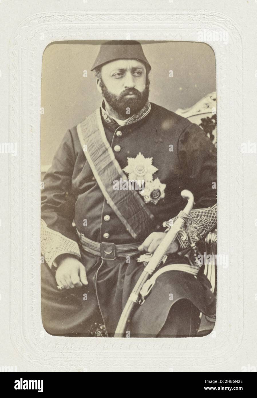 Ritratto di studio di un uomo stout in uniforme d'esercito con insegne sul petto e una spada sulla cintura, sulla sua testa l'uomo indossa un fez., Abdullah Frères (menzionato sull'oggetto), Istanboel, c.. 1863 - c. 1866, carta, cartone, stampa albume, altezza 80 mm x larghezza 54 mm altezza 296 mm x larghezza 225 mm Foto Stock