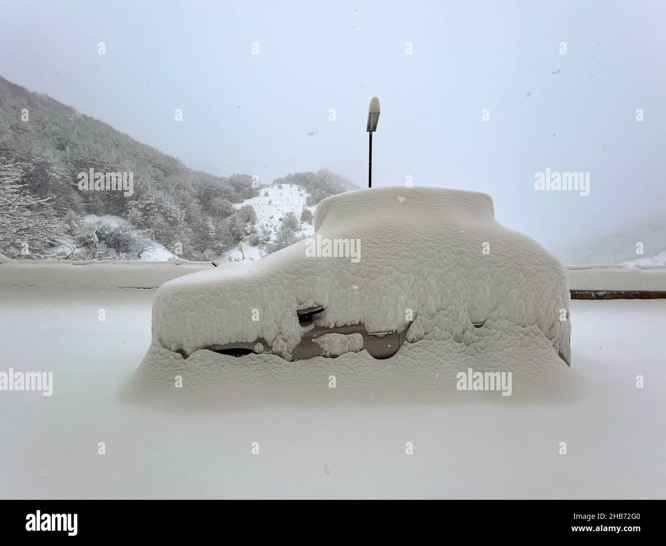 SUV coperto di neve profonda in un parcheggio Foto Stock