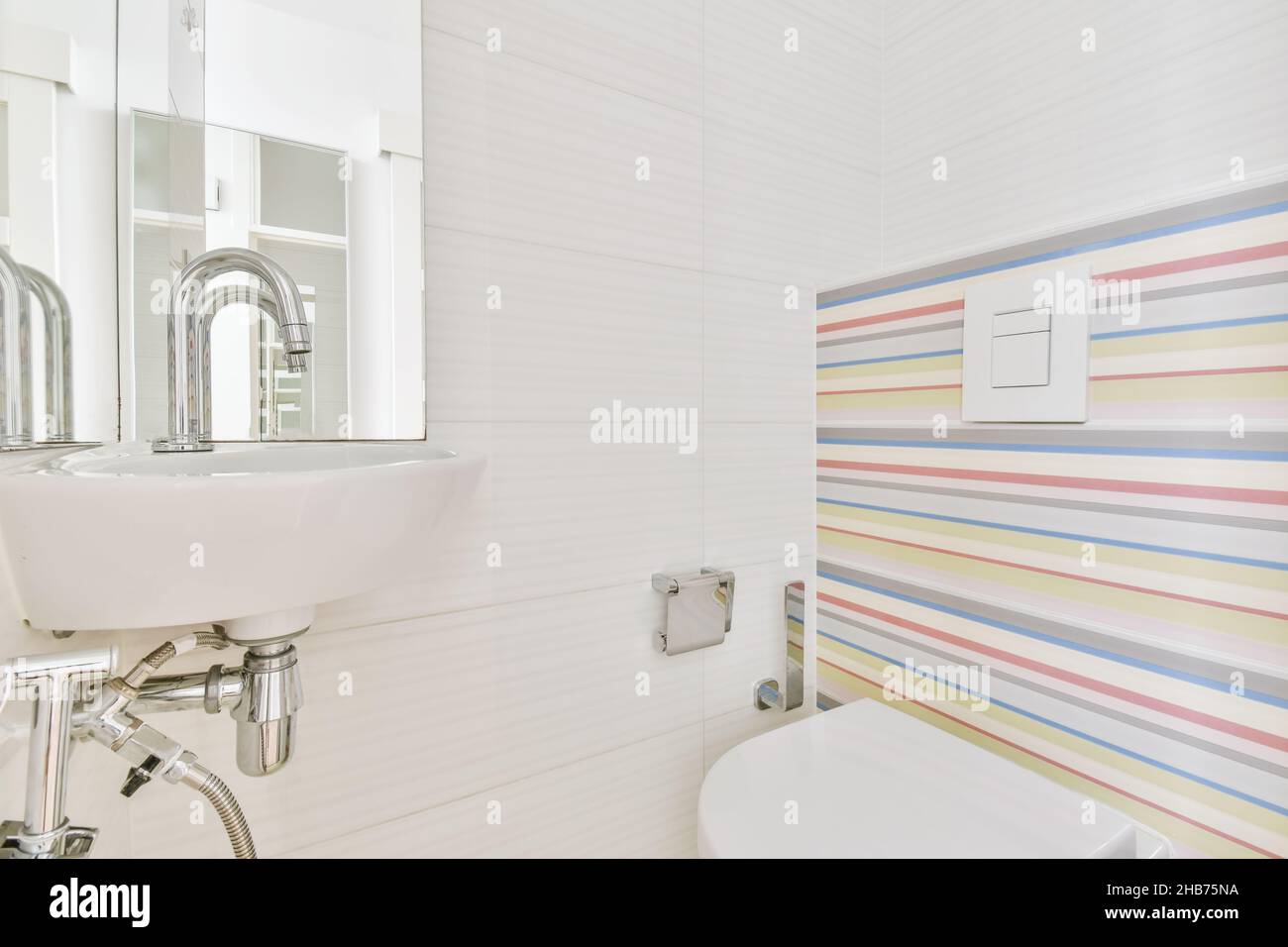 I bagni sono carini con carta da parati a righe sul retro del gabinetto sospeso Foto Stock