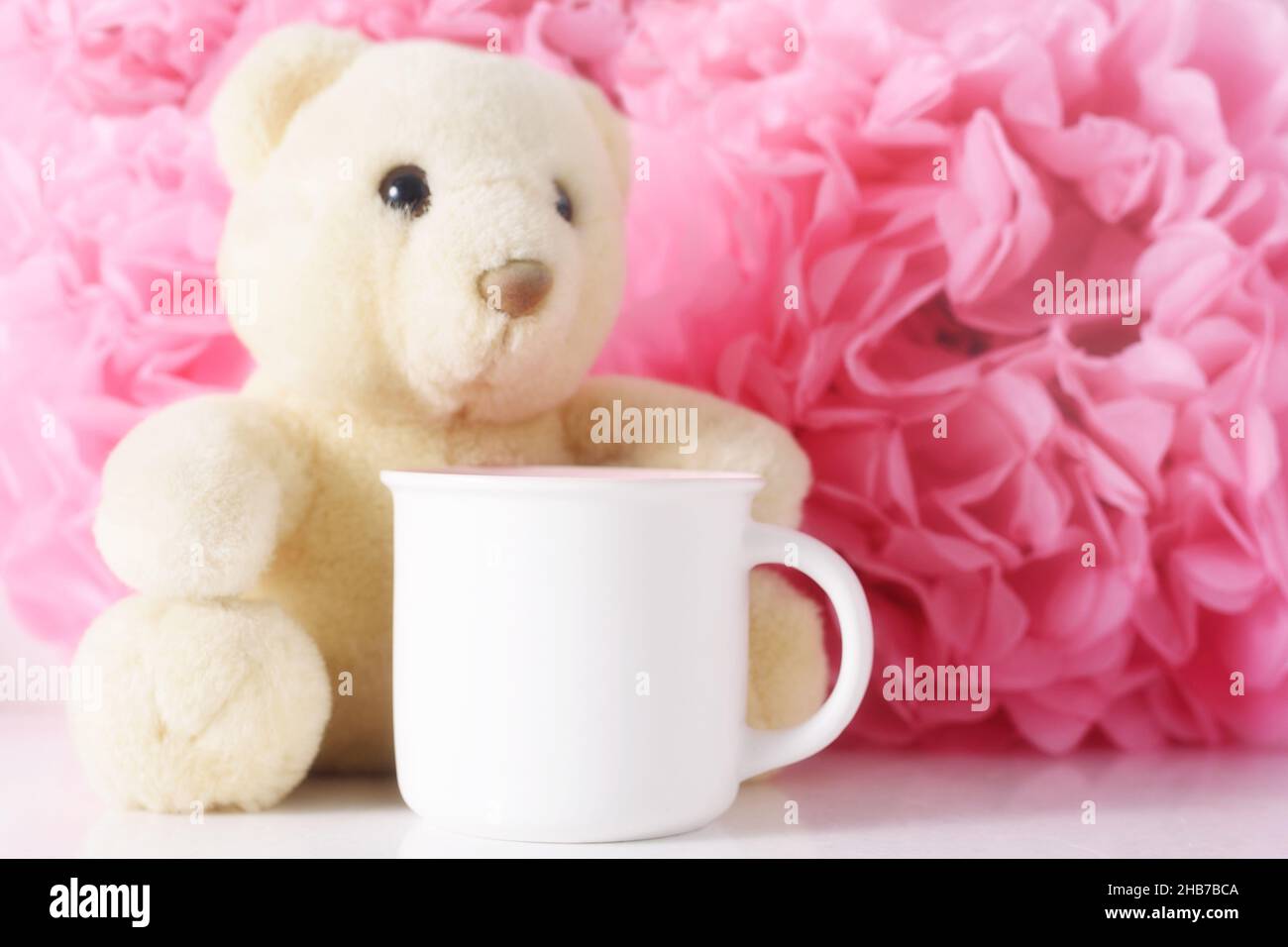 Tazza mockup bianca su sfondo di carta rosa fiori. Foto Stock