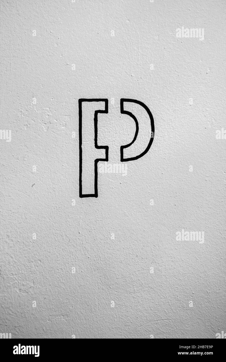 un cartello dipinto di nero che informa del parcheggio sulla parete bianca. Foto Stock