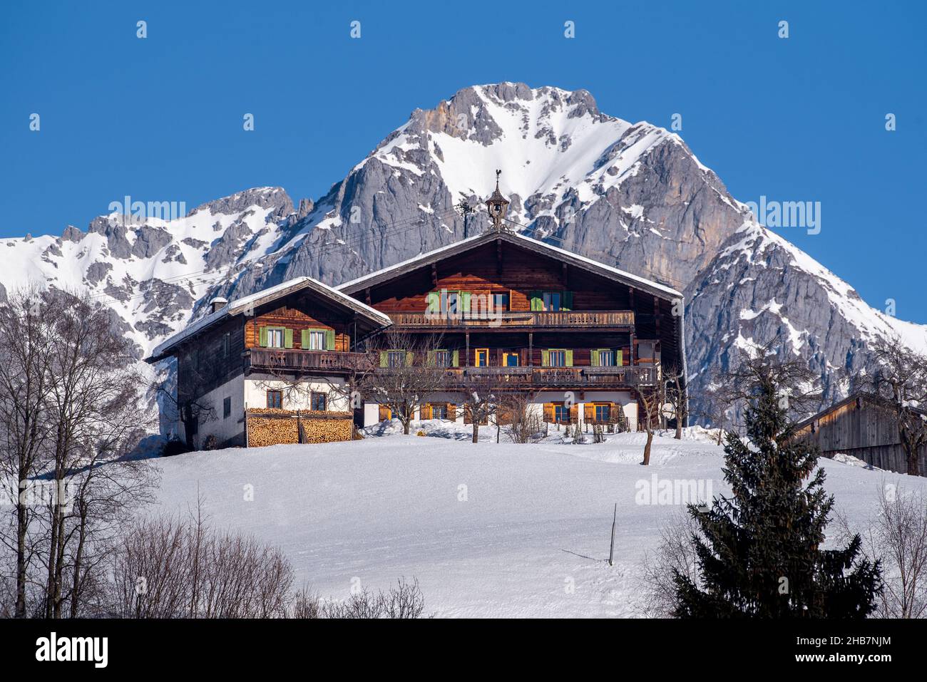Antica fattoria tradizionale in un idilliaco paesaggio invernale a Kitzbuehel, Tirolo, Austria Foto Stock