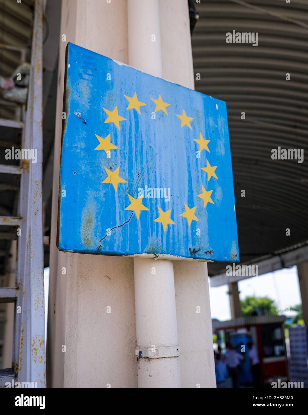 Immagine di profondità di campo poco profonda (fuoco selettivo) con un segno usurato e arrugginito al confine rumeno con il simbolo dell'Unione europea. Foto Stock