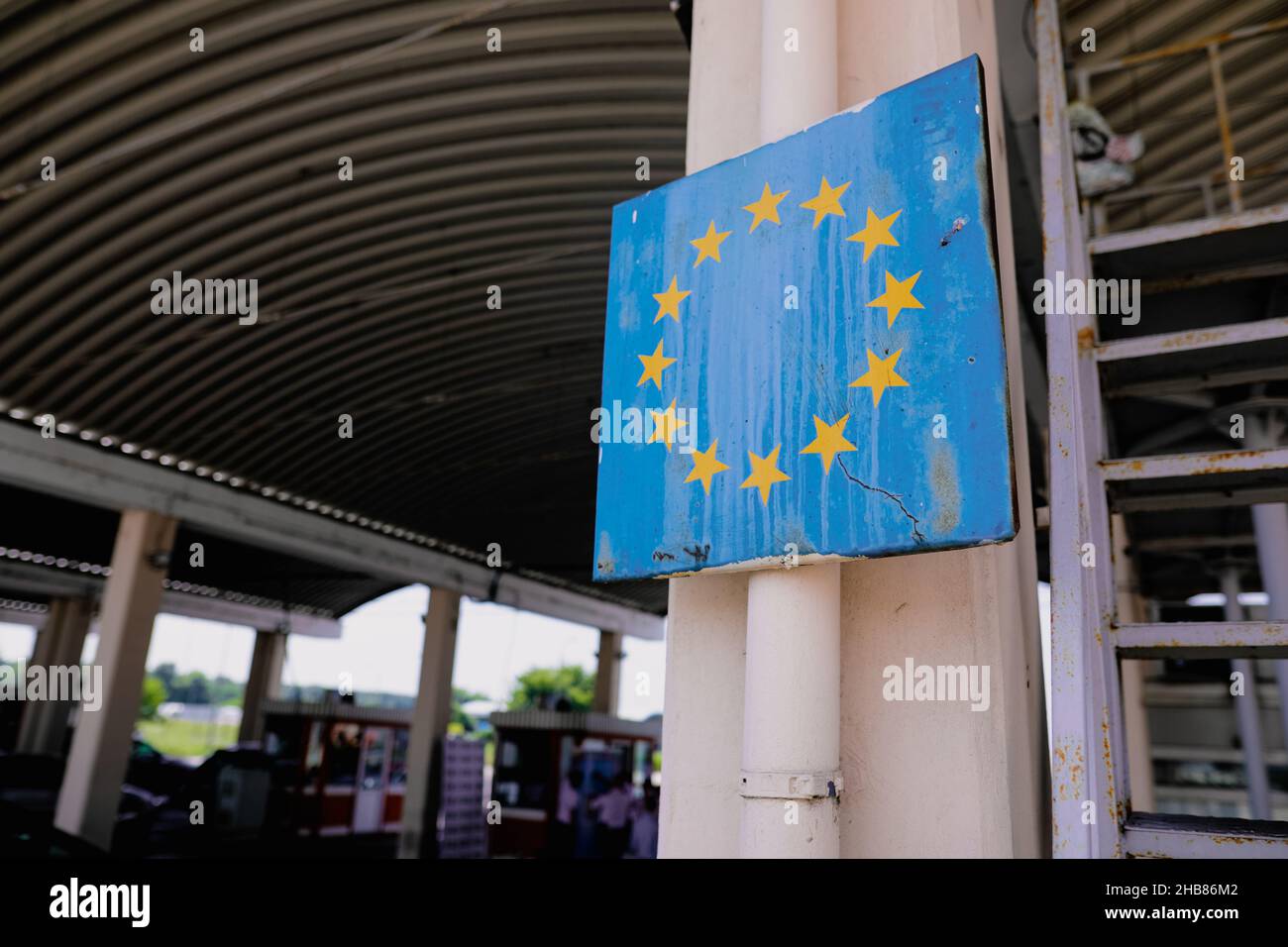 Immagine di profondità di campo poco profonda (fuoco selettivo) con un segno usurato e arrugginito al confine rumeno con il simbolo dell'Unione europea. Foto Stock