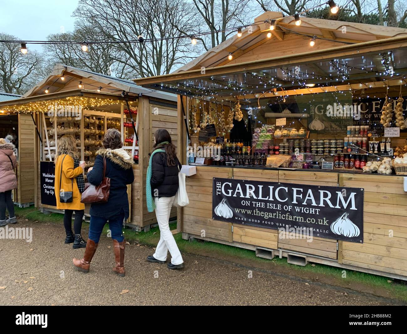 Waddeston Manor National Trust UK Garlic Farm cabine in legno persone in legno cammina cappotti di scalf comprare vendere cibo Isola di Wight mangiare luci Foto Stock