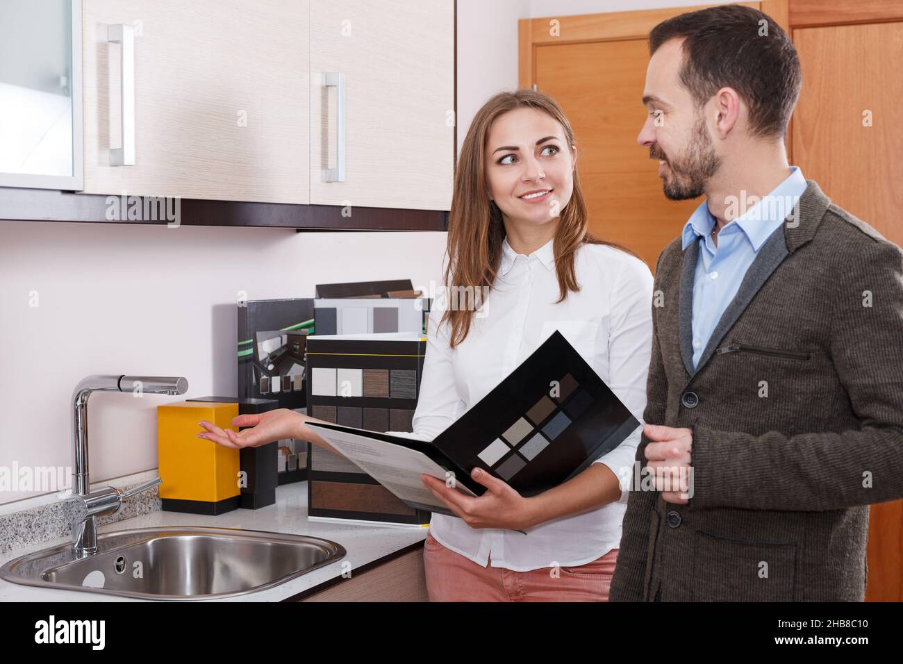 Giovane donna venditore consulenza uomo cliente in negozio di arredamento cucina Foto Stock