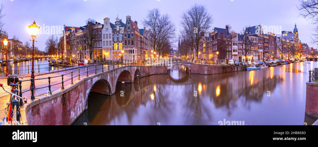 Panorama del canale di Amsterdam Keizersgracht con tipiche case olandesi e ponte durante l'ora blu mattina, Olanda, Paesi Bassi Foto Stock