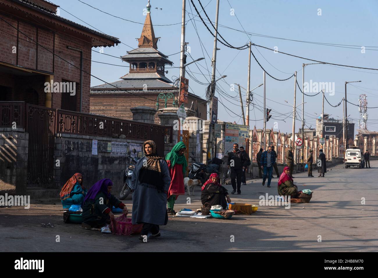 Srinagar, India. 17th Dic 2021. Le donne pescatrici attendono i clienti fuori da un chiuso Jamia Masjid a Srinagar.le autorità indiane vedono la moschea come un punto di difficoltà, un centro nevralgico per le proteste e gli scontri che sfidano la sovranità dell'India sulla regione del Kashmir. Per i musulmani del Kashmiri, è un luogo sacro per le preghiere del venerdì e un luogo in cui possono alzare la voce per i diritti politici. In questa disputa amara, la moschea nella città principale del Kashmir è rimasta in gran parte chiusa per 19 venerdì consecutivi. Credit: SOPA Images Limited/Alamy Live News Foto Stock