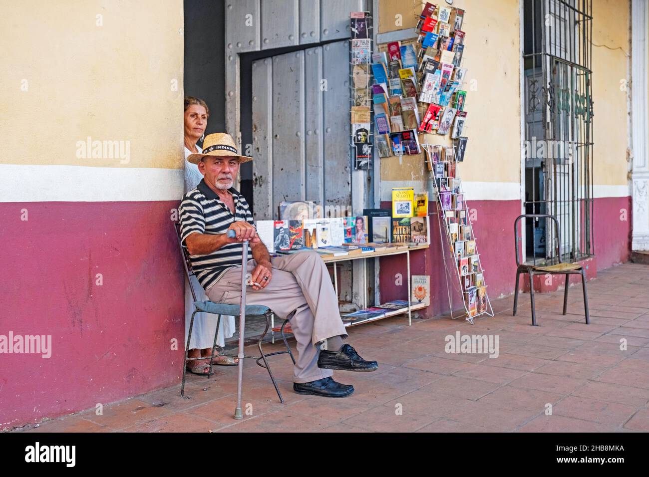 Orgoglioso libraio cubano che si posa di fronte alla sua piccola libreria / libreria nella città Sancti Spíritus sull'isola Cuba, Caraibi Foto Stock