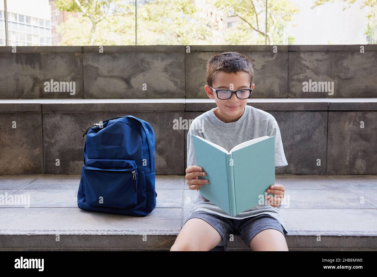 USA, New York, New York City, Boy (8-9) con zaino in esecuzione passi scuola Foto Stock