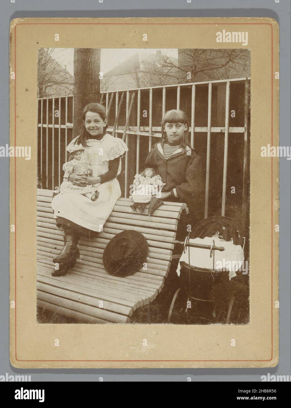 Ritratto di due ragazze sconosciute con bambole accanto ad un passeggino, anonimo, Paesi Bassi, c.. 1895 - c. 1910, supporto fotografico, altezza 102 mm x larghezza 79 mm Foto Stock