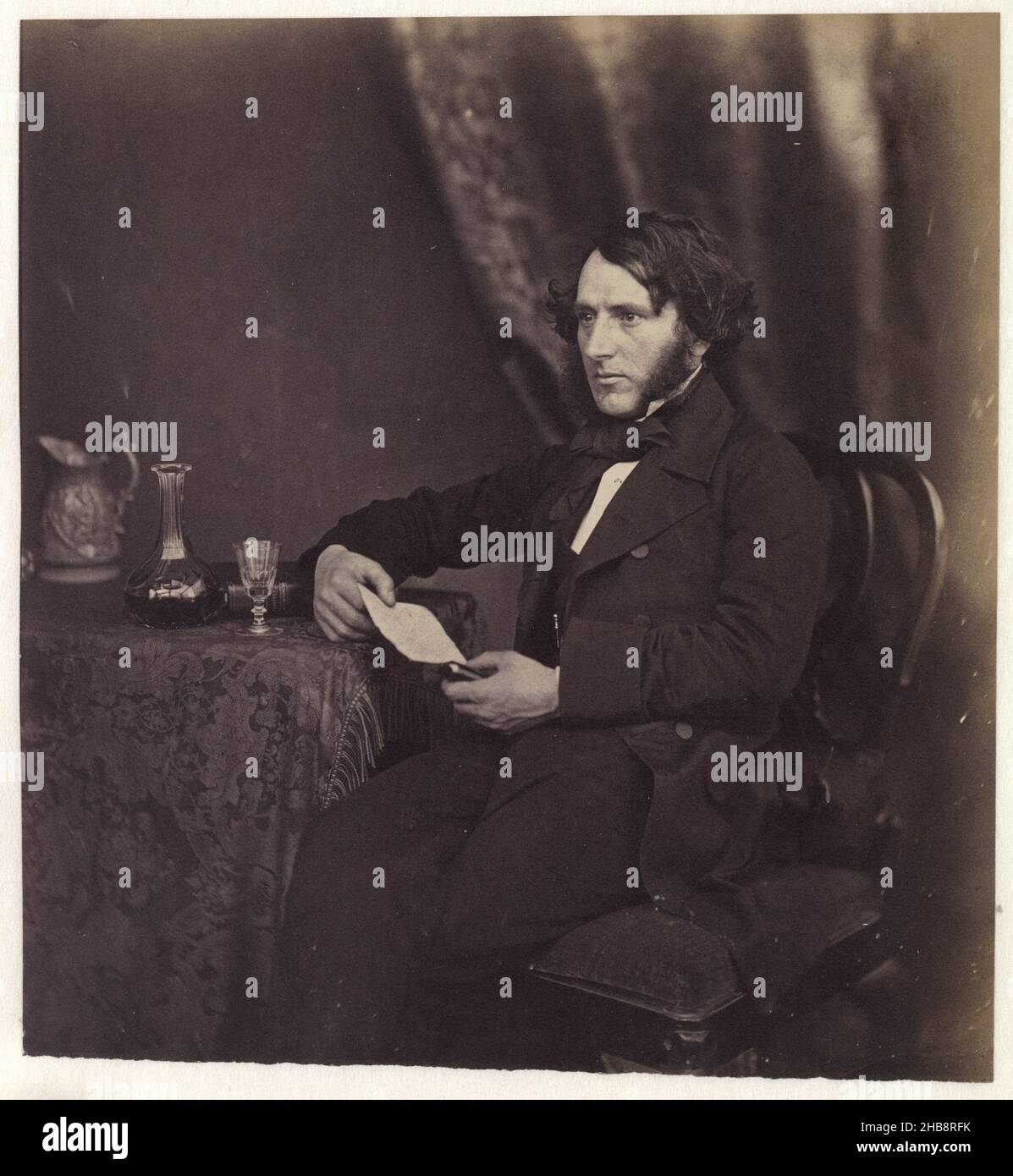 Ritratto di un uomo sconosciuto ad un tavolo con una lettera in mano, Roger Fenton (modo di), Gran Bretagna, 1855 - c.. 1865, supporto fotografico, stampa su carta salata, altezza 175 mm x larghezza 165 mm Foto Stock