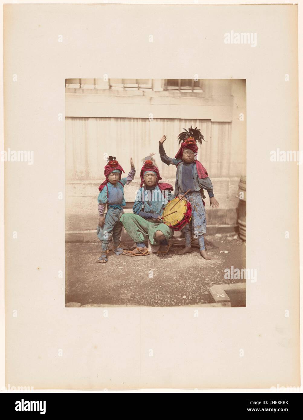 Giovani artisti di strada giapponesi con un tamburo, Jongleurs de rue (titolo originale), Raimund von Stillfried-Ratenitz (attribuito a), Yokohama, 1871 - 1881, carta, cartone, stampa albume, altezza 240 mm x larghezza 910 mm altezza 403 mm x larghezza 310 mm Foto Stock