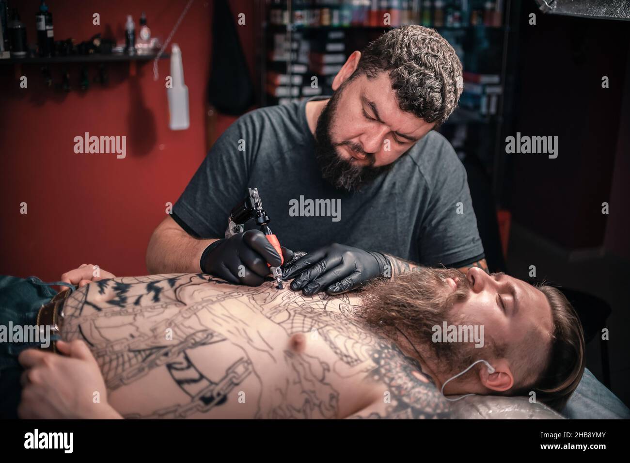 Tatuaggio artista che fa tatuaggio in salotto tatuaggio Foto Stock