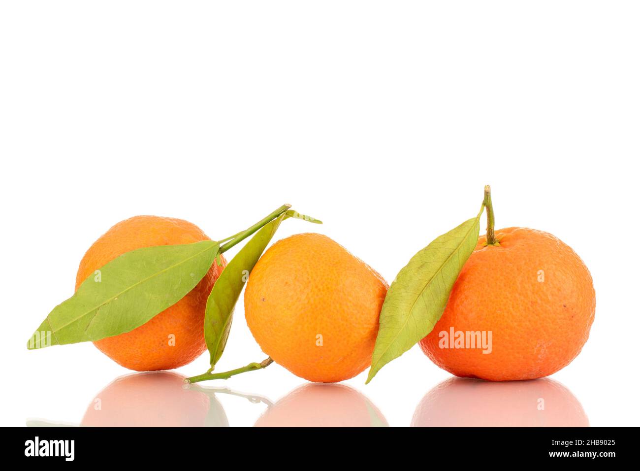 Tre tangerini maturi arancioni brillanti, primo piano, isolati su bianco. Foto Stock