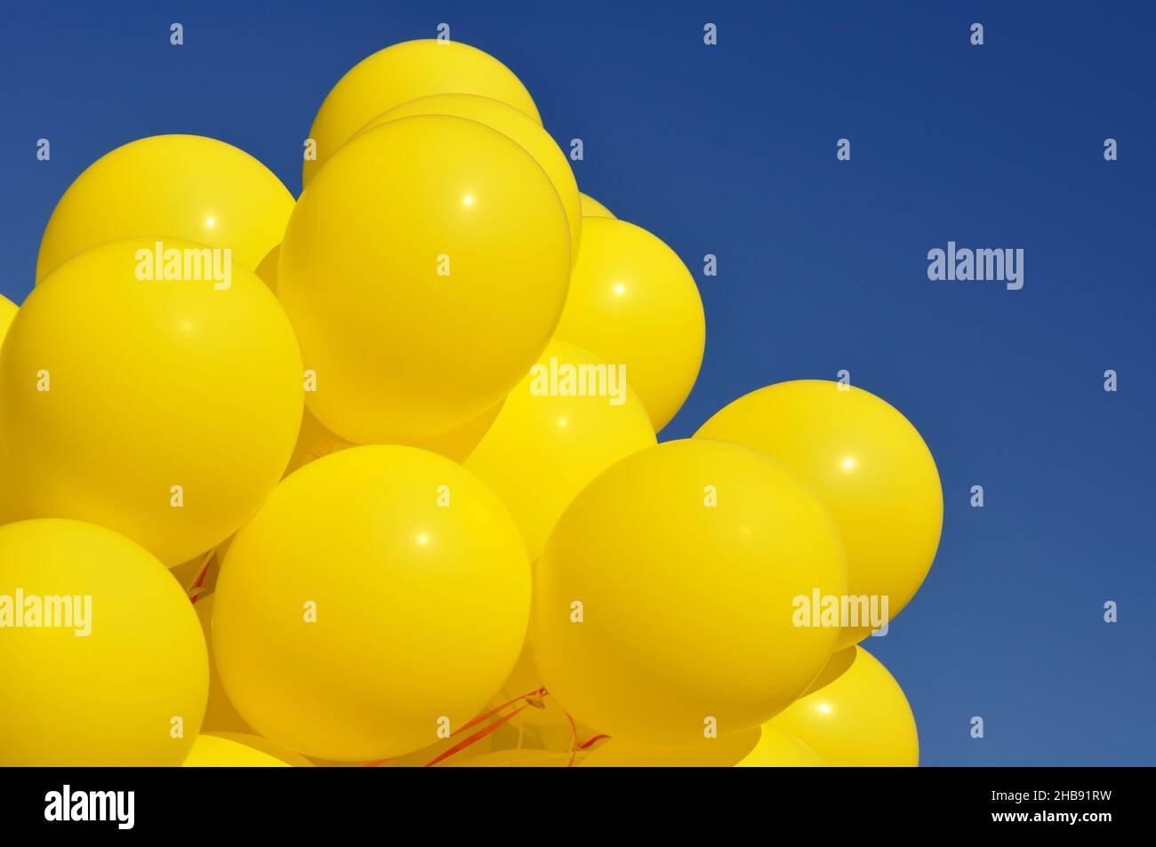 palloncini gialli nel festival della città contro il cielo blu profondo Foto Stock