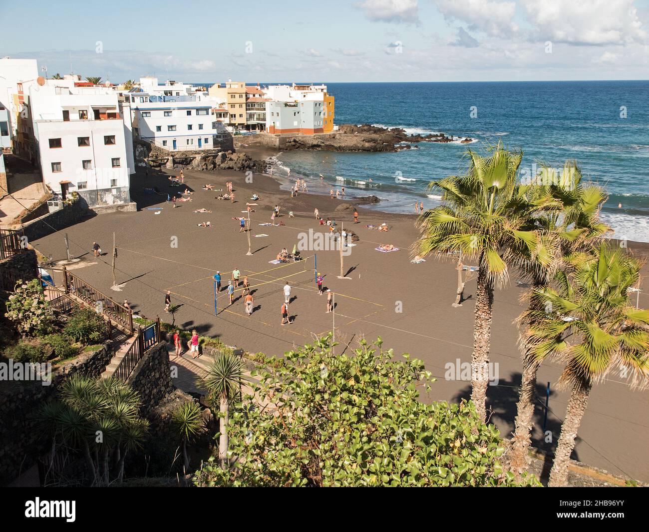 I turisti prendono il sole sulla spiaggia di sabbia scura di Playa Maria Jiménez a Garachico, Puerto de la Cruz Foto Stock