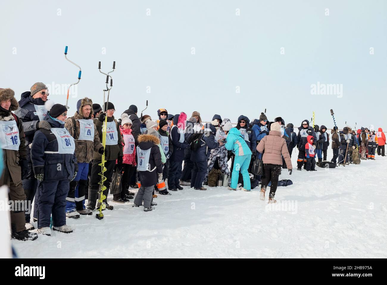 Dudinka, Krasnoyarsk Territory, Russia, 13 aprile 2019: Pescatori con numeri sul loro petto in fila prima dell'inizio della costola di pesca del ghiaccio Foto Stock