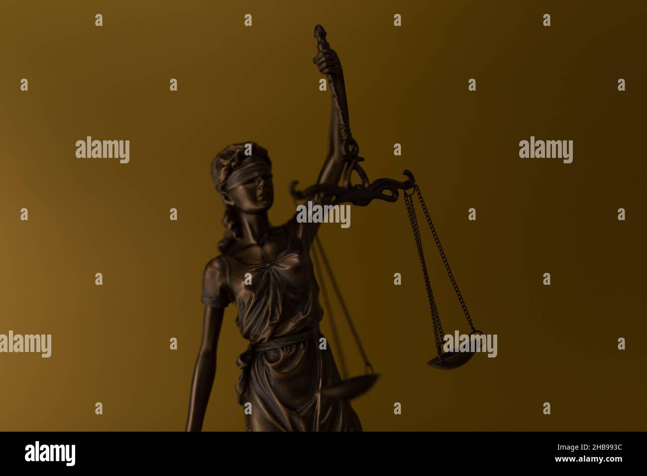Statua di bronzo di una donna con le scale come simbolo di legge e giustizia su uno sfondo dorato Foto Stock Statua di bronzo di una donna con le scale come simbolo di legge e giustizia su uno sfondo dorato Foto Stock