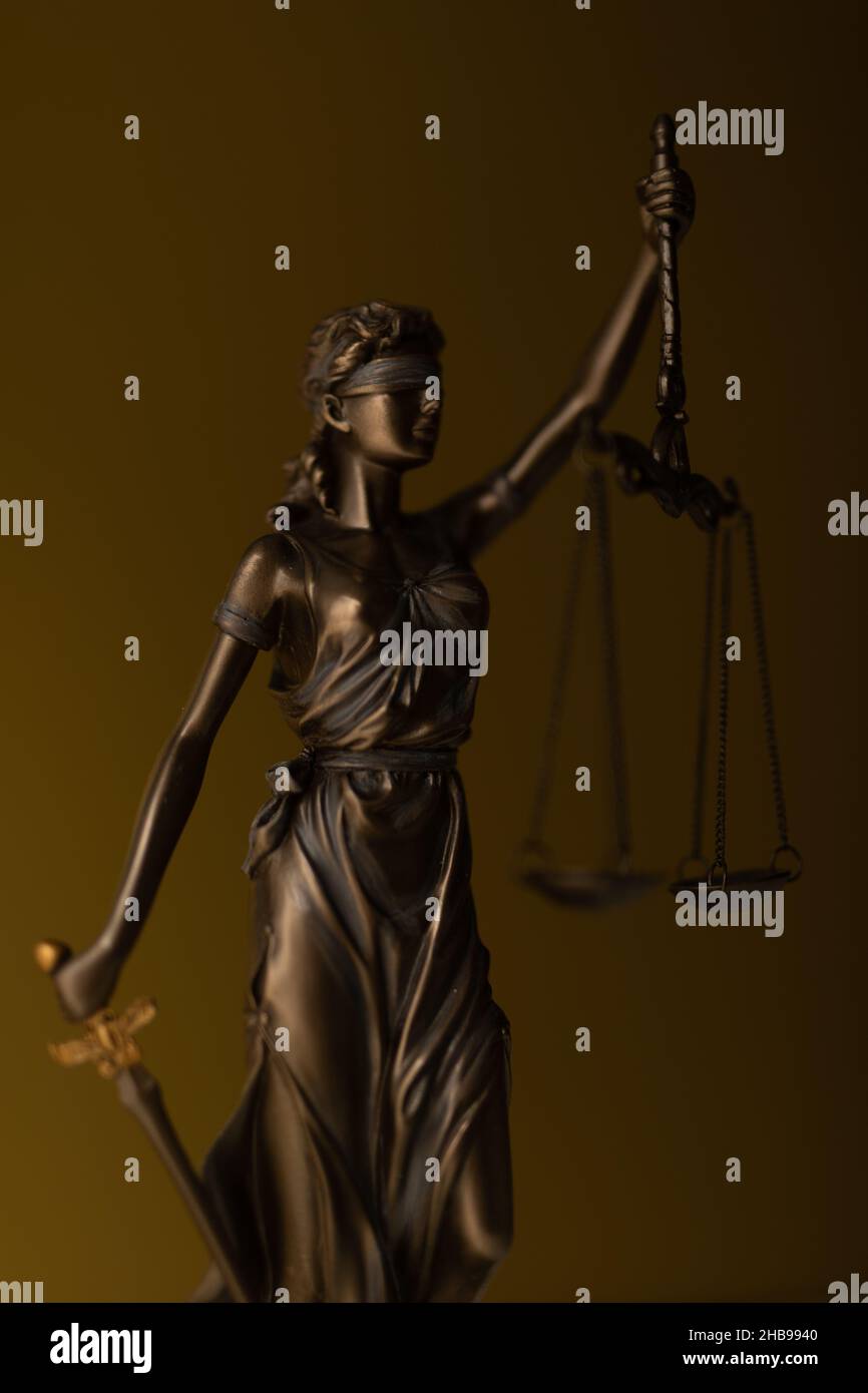 Statua di bronzo di una donna con le scale come simbolo di legge e giustizia su uno sfondo dorato Foto Stock Statua di bronzo di una donna con le scale come simbolo di legge e giustizia su uno sfondo dorato Foto Stock