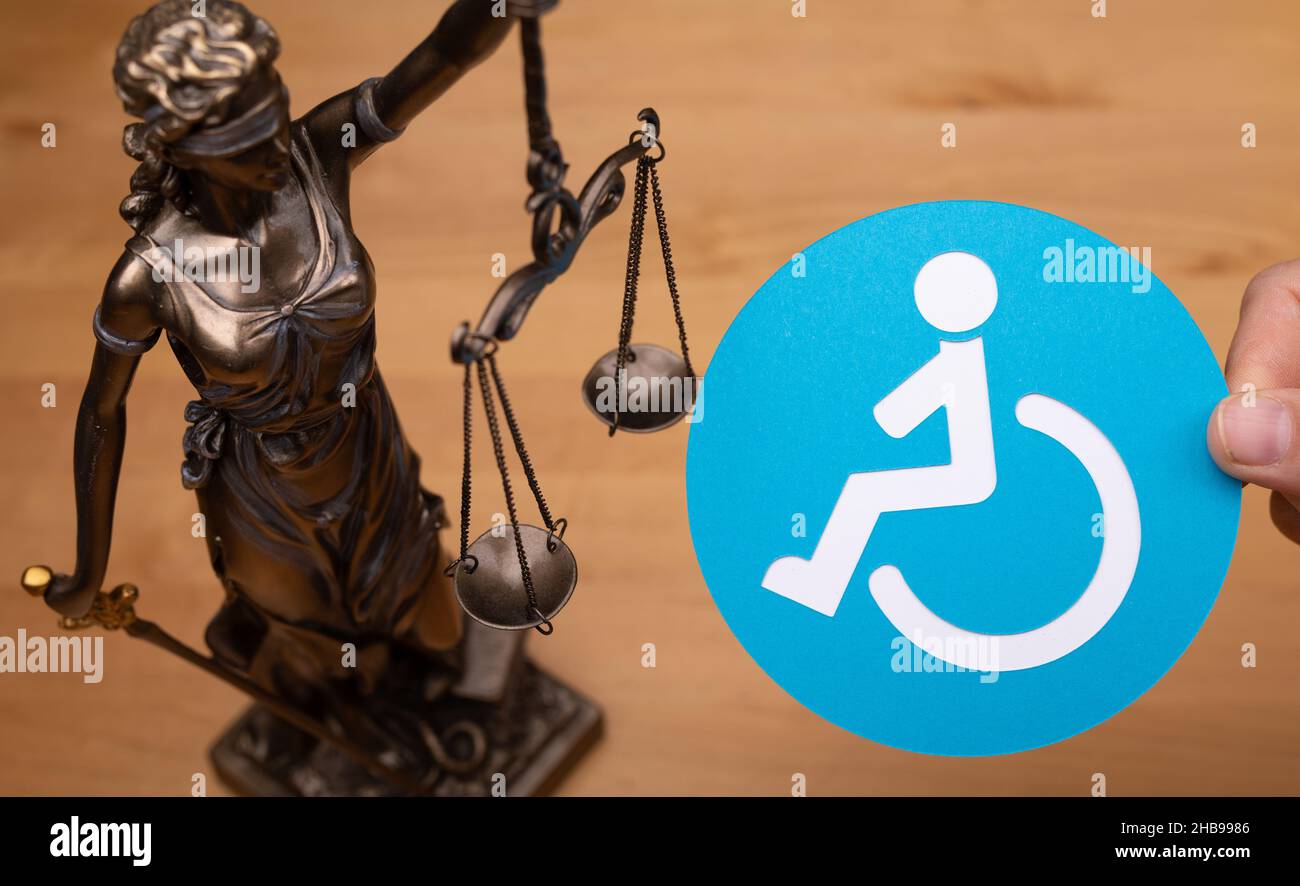 Statua di una donna con le scale come simbolo di legge e le persone disabili segno su una superficie di legno Foto Stock Statua di una donna con le scale come simbolo di legge e le persone disabili segno su una superficie di legno Foto Stock