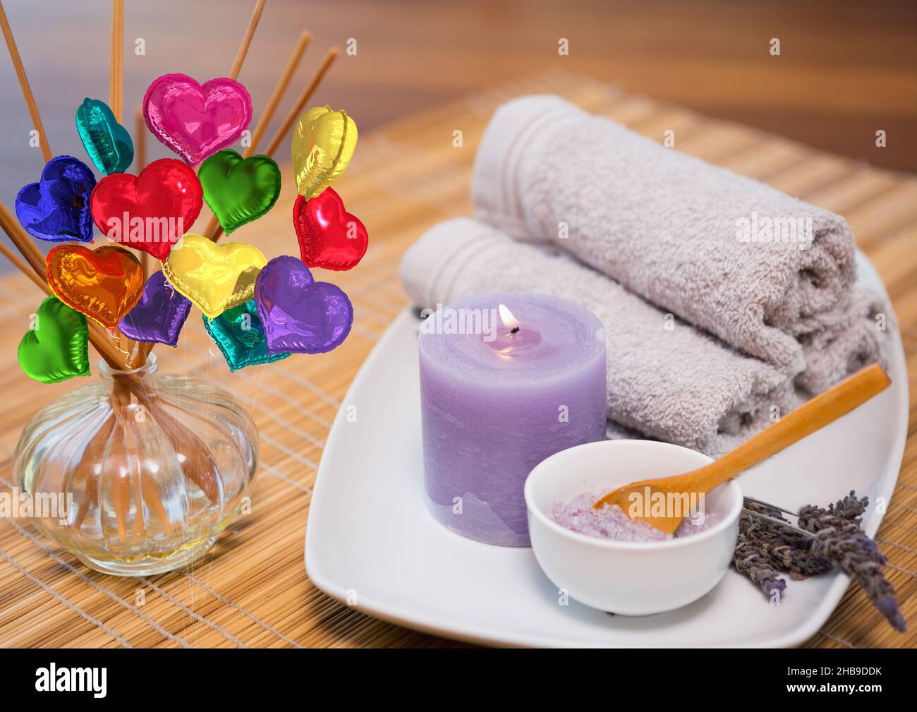 Immagine composita di palloncini colorati a forma di cuore contro asciugamano, candela e sale da bagno Foto Stock