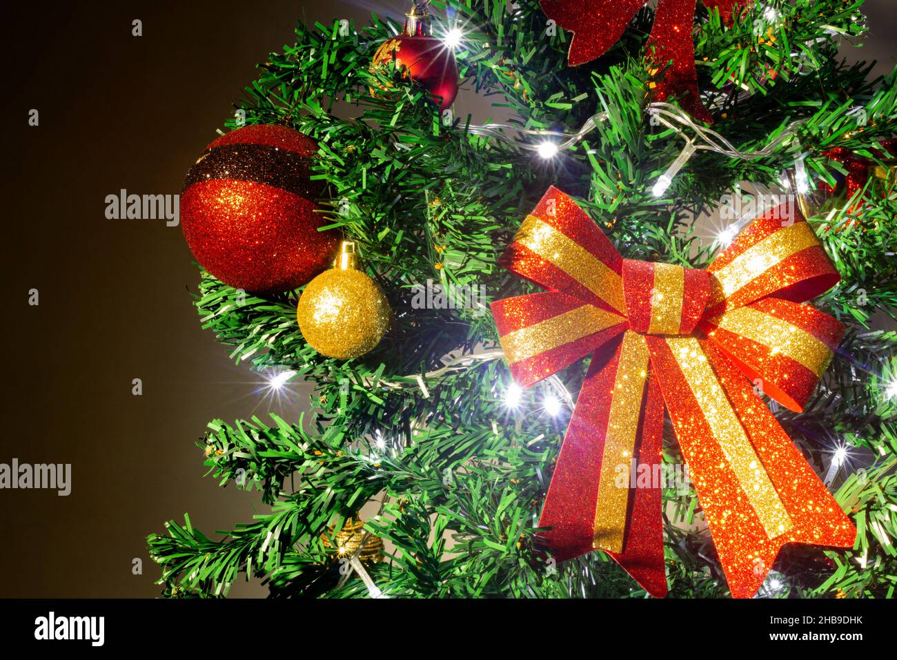 Primo piano di decorazioni su un albero di Natale con luci accese Foto Stock