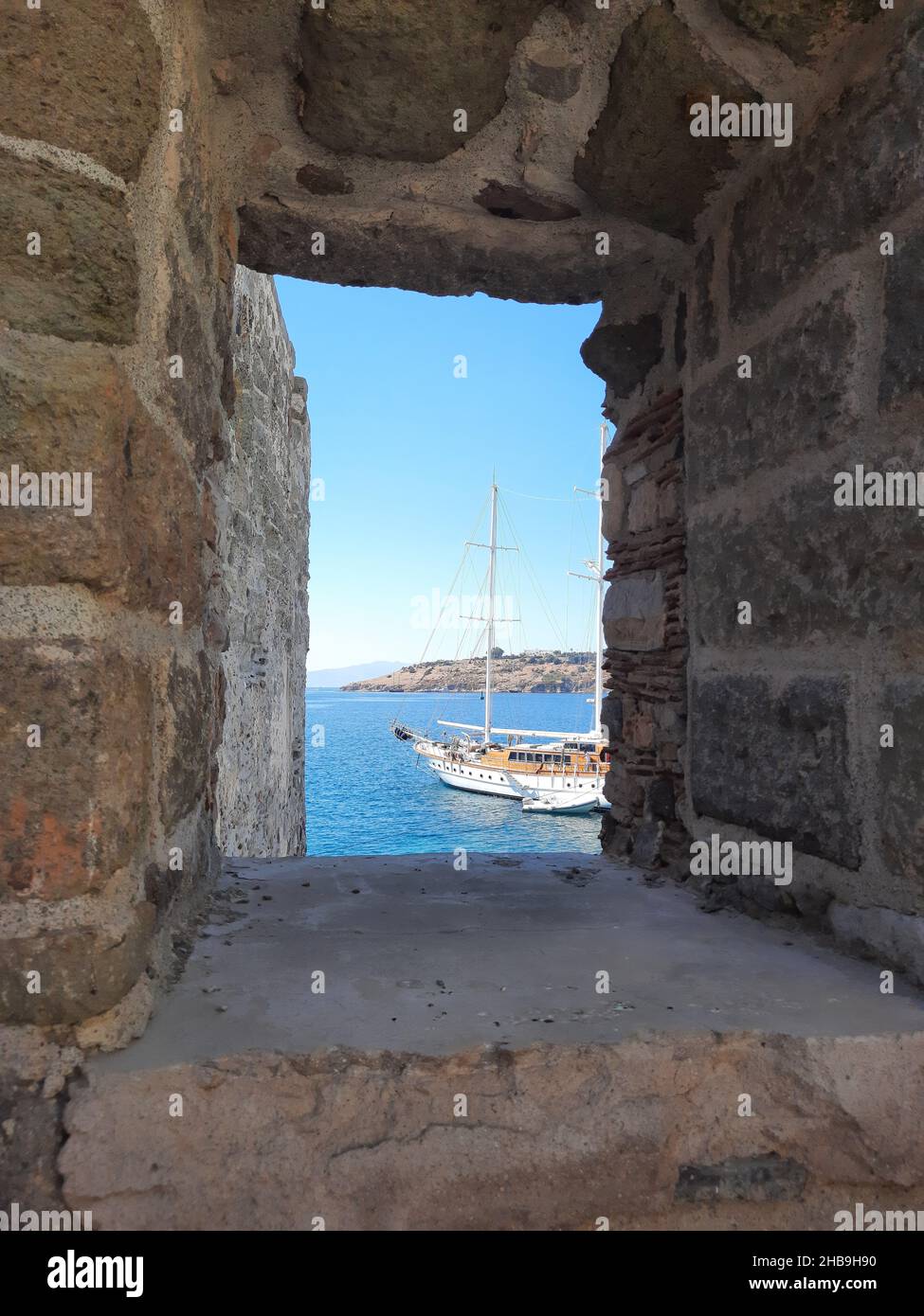 Vista sul mare con yacht attraverso le mura del Castello di San Pietro a Bodrum. Turchia. Foto Stock