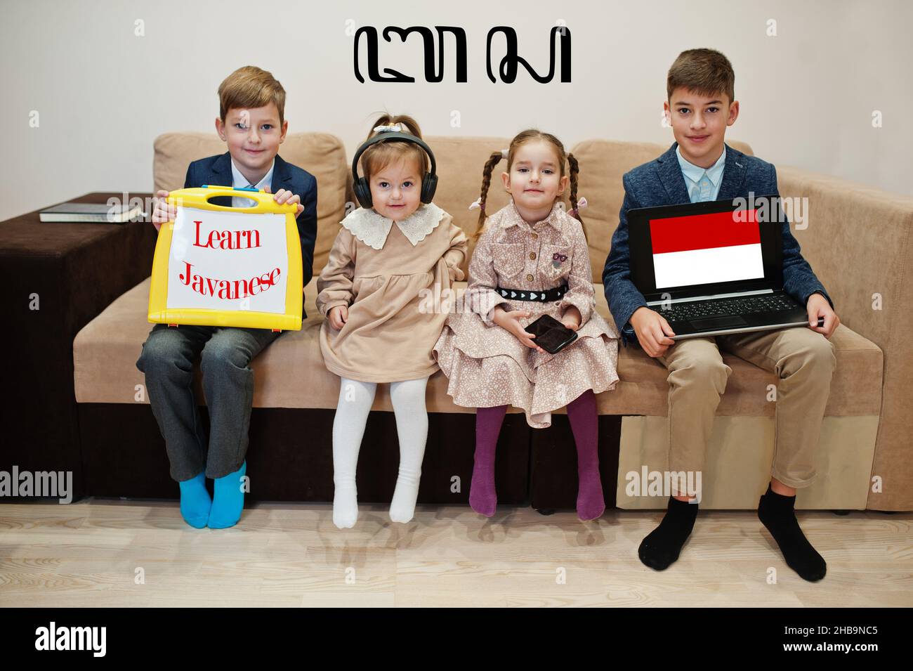 Quattro bambini mostrano iscrizione imparare giavanese. Concetto di apprendimento delle lingue straniere. Foto Stock