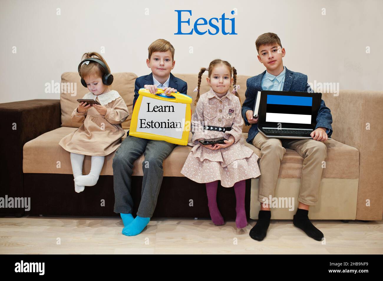 Quattro bambini mostrano iscrizione imparare estone. Concetto di apprendimento delle lingue straniere. Eesti. Foto Stock