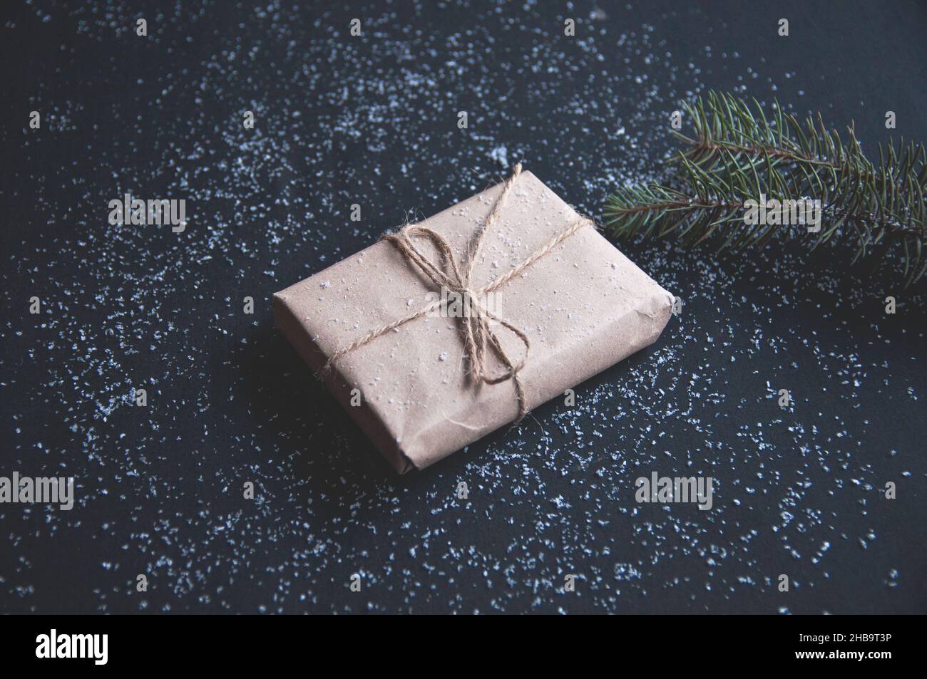 Scatola regalo o regalo e neve su un tavolo nero. Design piatto per compleanno, giorno della madre, Black friday Foto Stock