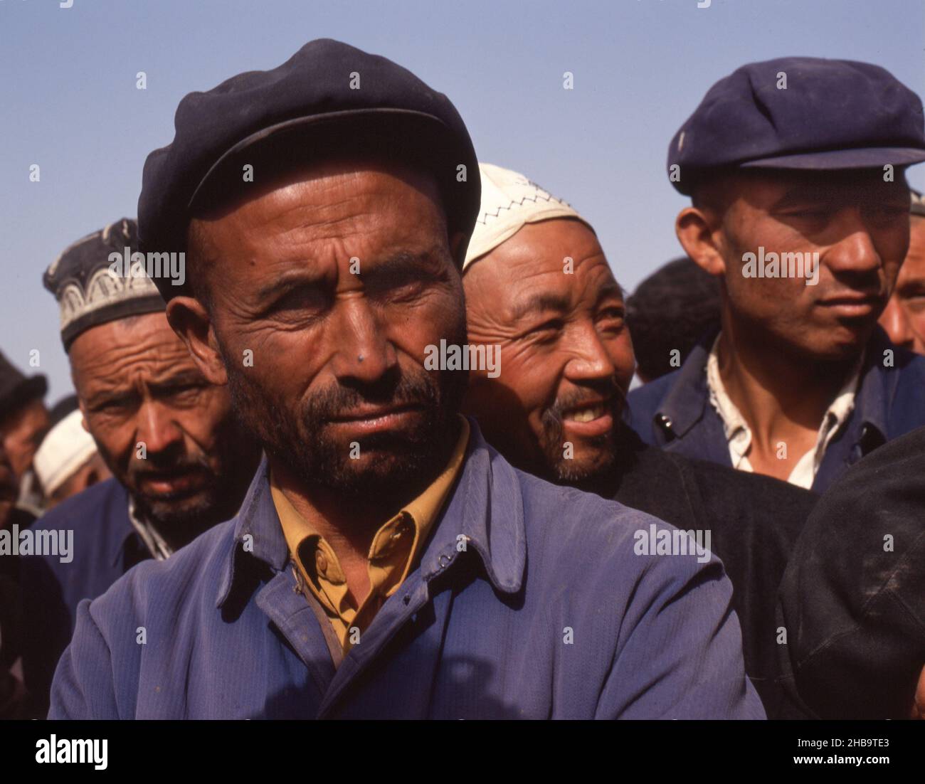 Uyghur uomini in un mercato di cavalli all'aperto a Kashgar, Cina nel 1988. Foto Stock