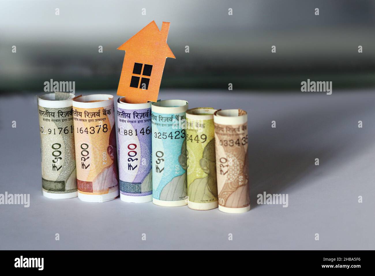Banconote indiane con 2D carta modello casa con chiave, risparmiare denaro per il futuro piano casa, concetto di business immobiliare Foto Stock