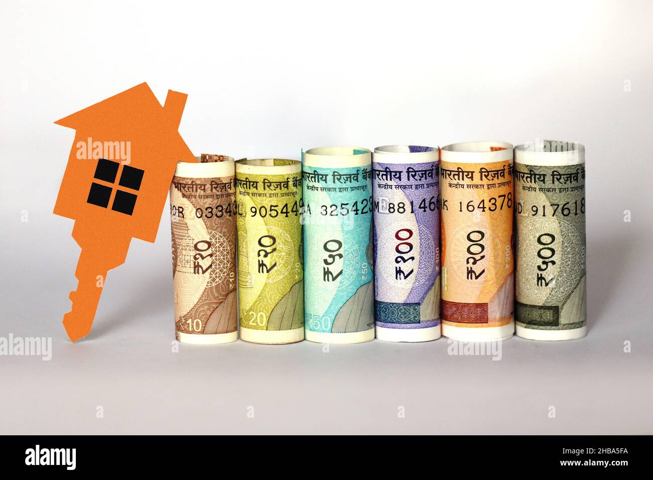 Banconote indiane con 2D carta modello casa con chiave, risparmiare denaro per il futuro piano casa, concetto di business immobiliare Foto Stock