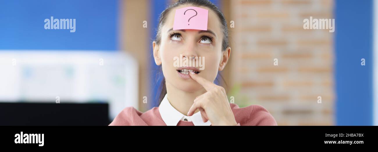 Donna pensiva sulla testa con adesivo con punto interrogativo Foto Stock