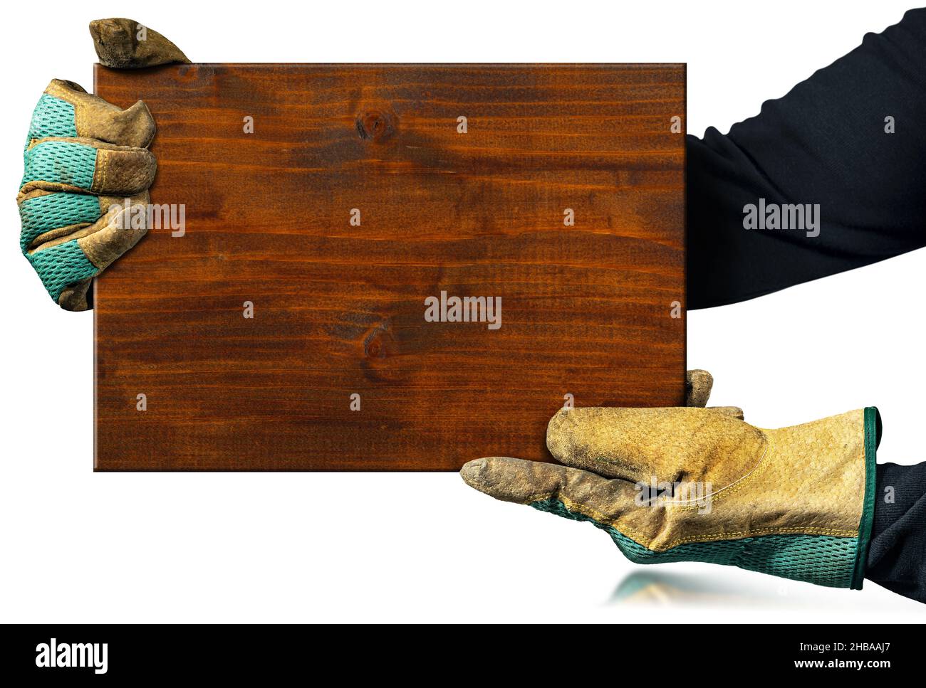 Carpentiere con guanti da lavoro protettivi che reggono una tavola di legno marrone isolata su sfondo bianco. Foto Stock