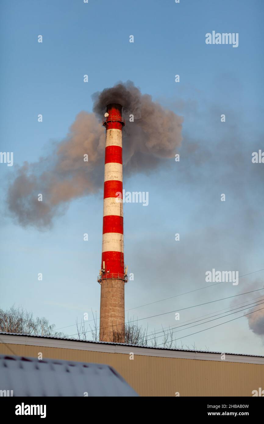 Fumo bianco spesso dal camino del locale caldaia. Fumo contro il cielo blu. Inquinamento atmosferico. Riscaldamento della città. Zona industriale. Foto Stock