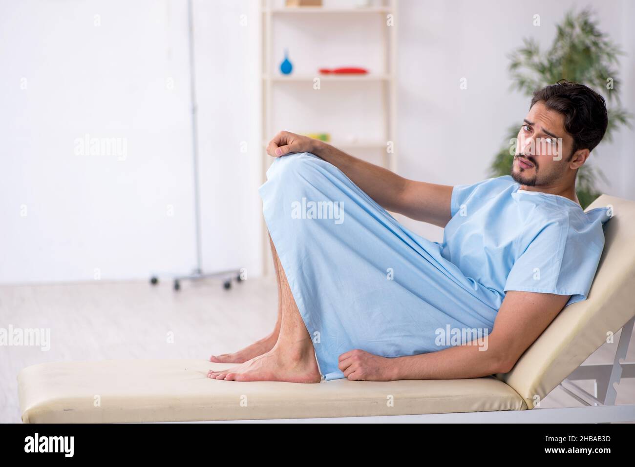 Paziente giovane in attesa di medico in clinica Foto Stock