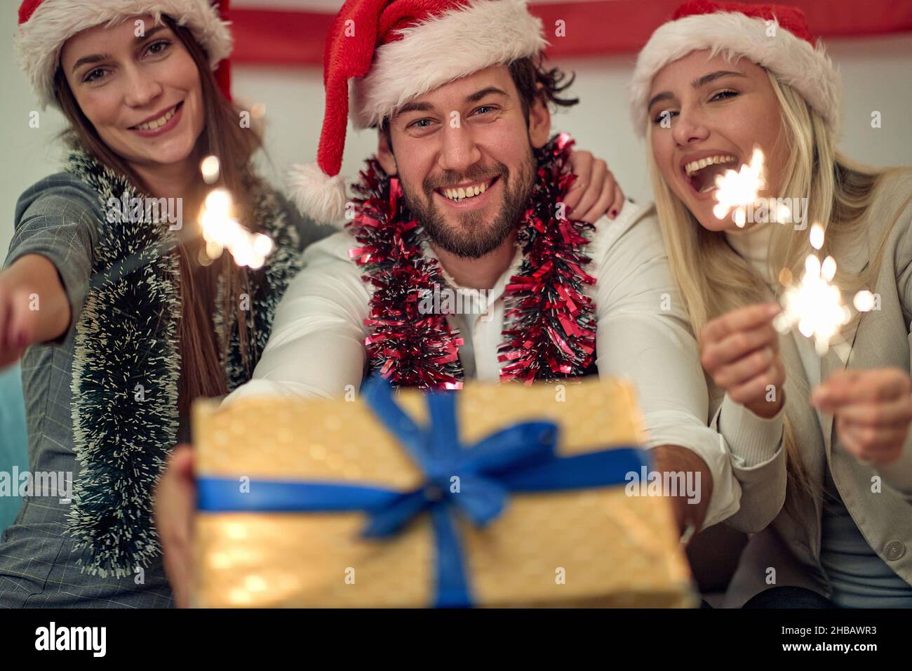 Giovani con scintille e regalo godendo in festa il giorno di Natale Foto Stock