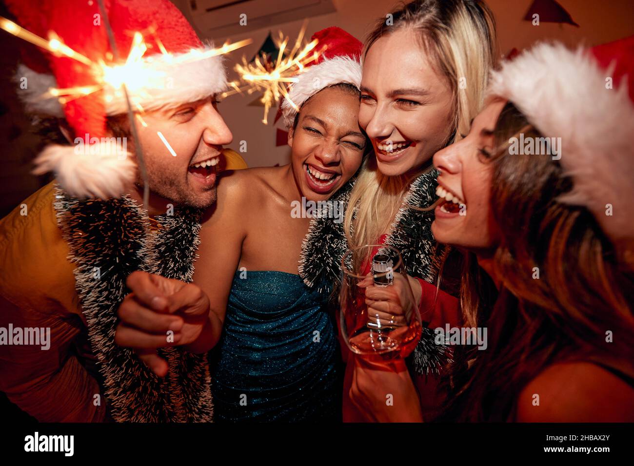 Primo piano di un gruppo di amici allegri alla festa di Capodanno in un'atmosfera festosa a casa. Natale, Capodanno, festa, festa Foto Stock