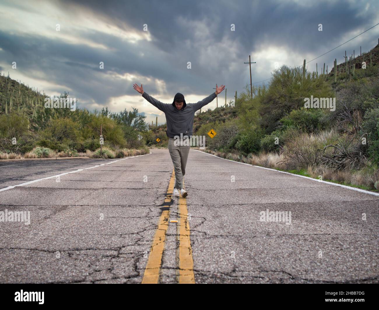 Giovane uomo in mezzo alla strada di campagna a piedi Foto Stock