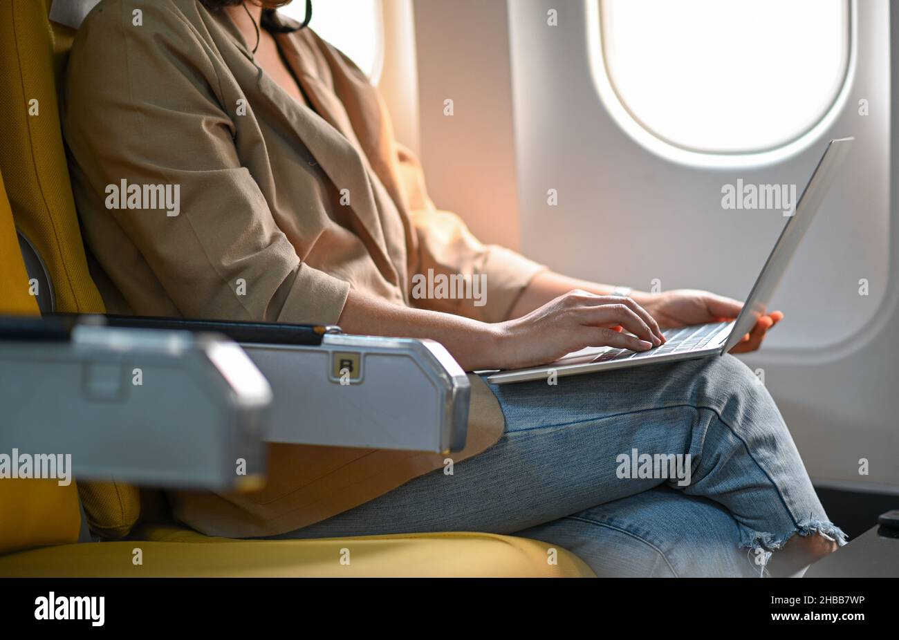 Donna che utilizza un computer portatile durante un volo in aereo Foto  stock - Alamy
