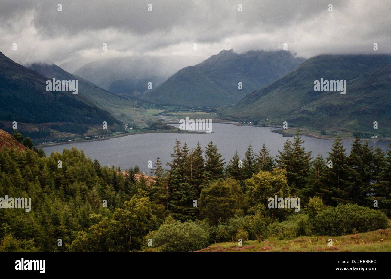 Immagine di archivio (scannerizzata dalla trasparenza) Montagne e Loch con tempesta di pioggia distante, Highlands occidentali della Scozia, 1990 Foto Stock